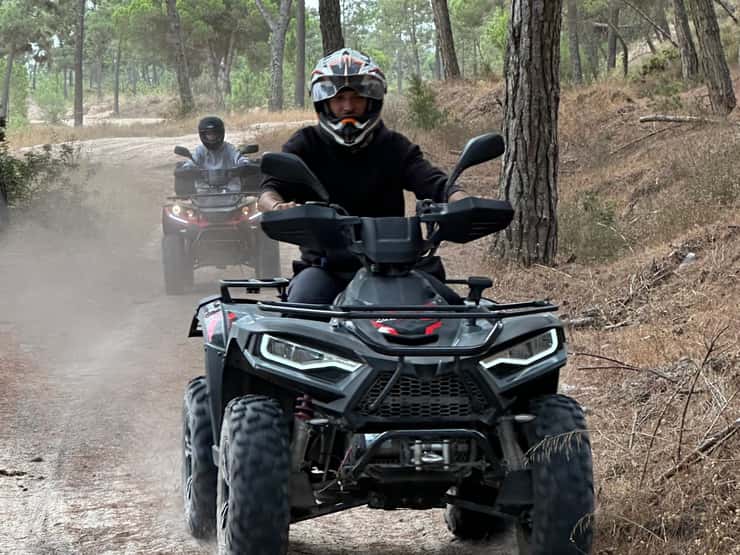 Participants riding quads through the pinhal
