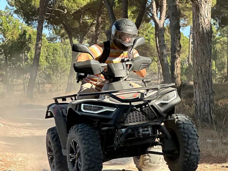 Quad rider navigating the forest terrain